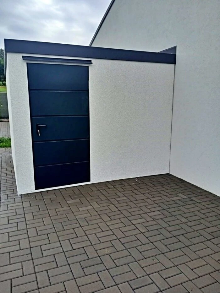 Montovaný záhradný domček s oceľovými dverami pri rodinnom dome