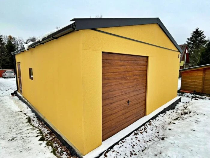 Montovaná dvojgaráž so sedlovou strechou a žltou omietkou